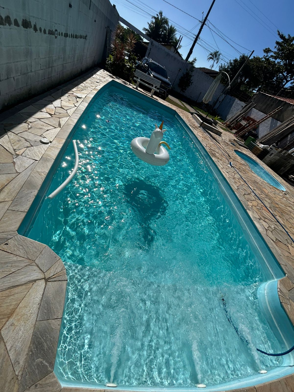 Piscina com água cristalina e cascata tratada por Luan Piscinas