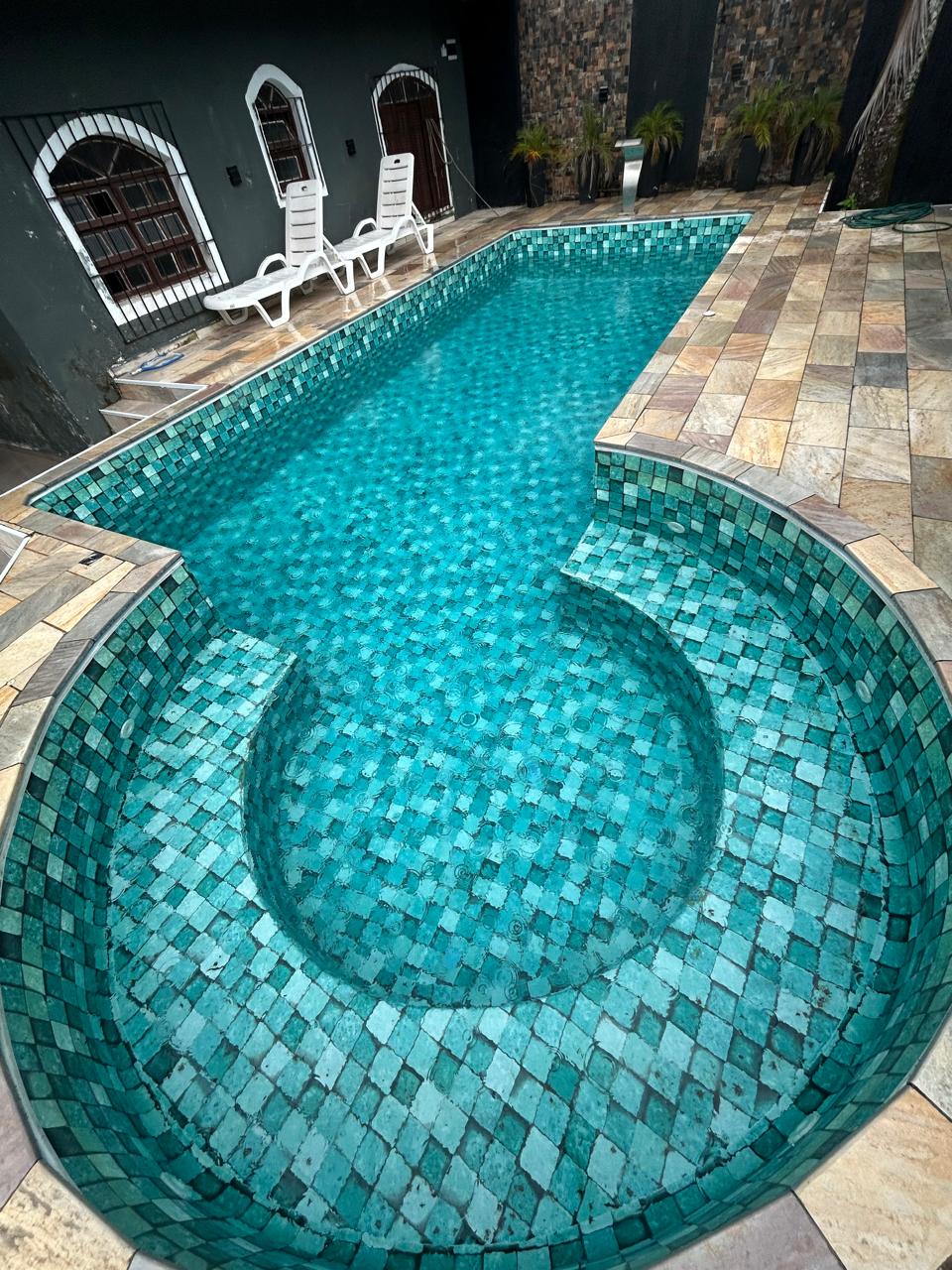 Piscina com revestimento em mosaico e água tratada por Luan Piscinas